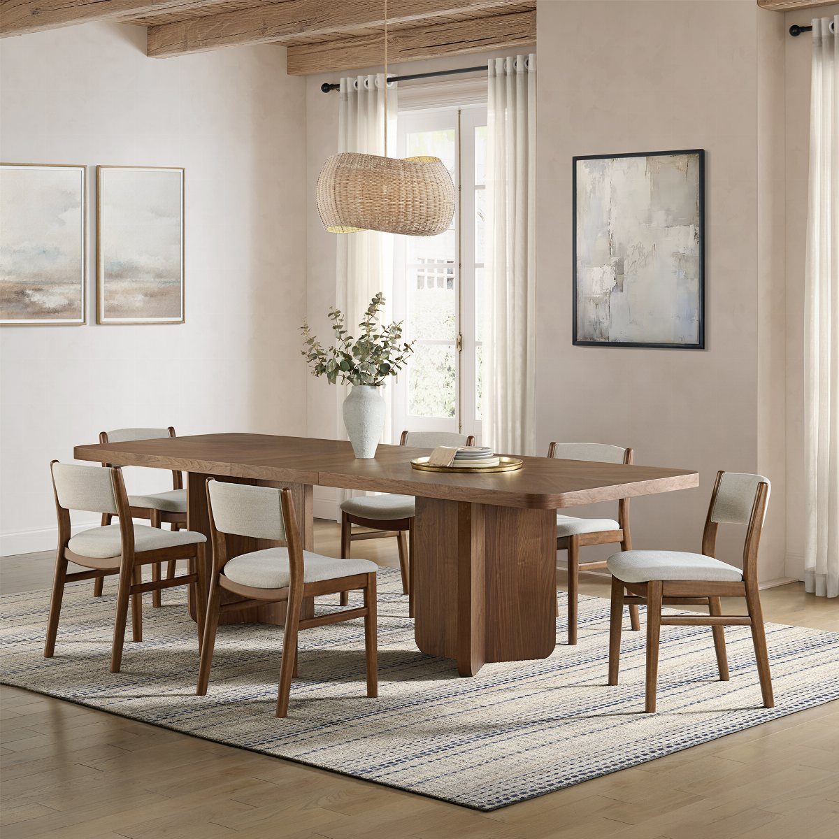 Wooden dining table with six matching chairs on a patterned rug in a room.