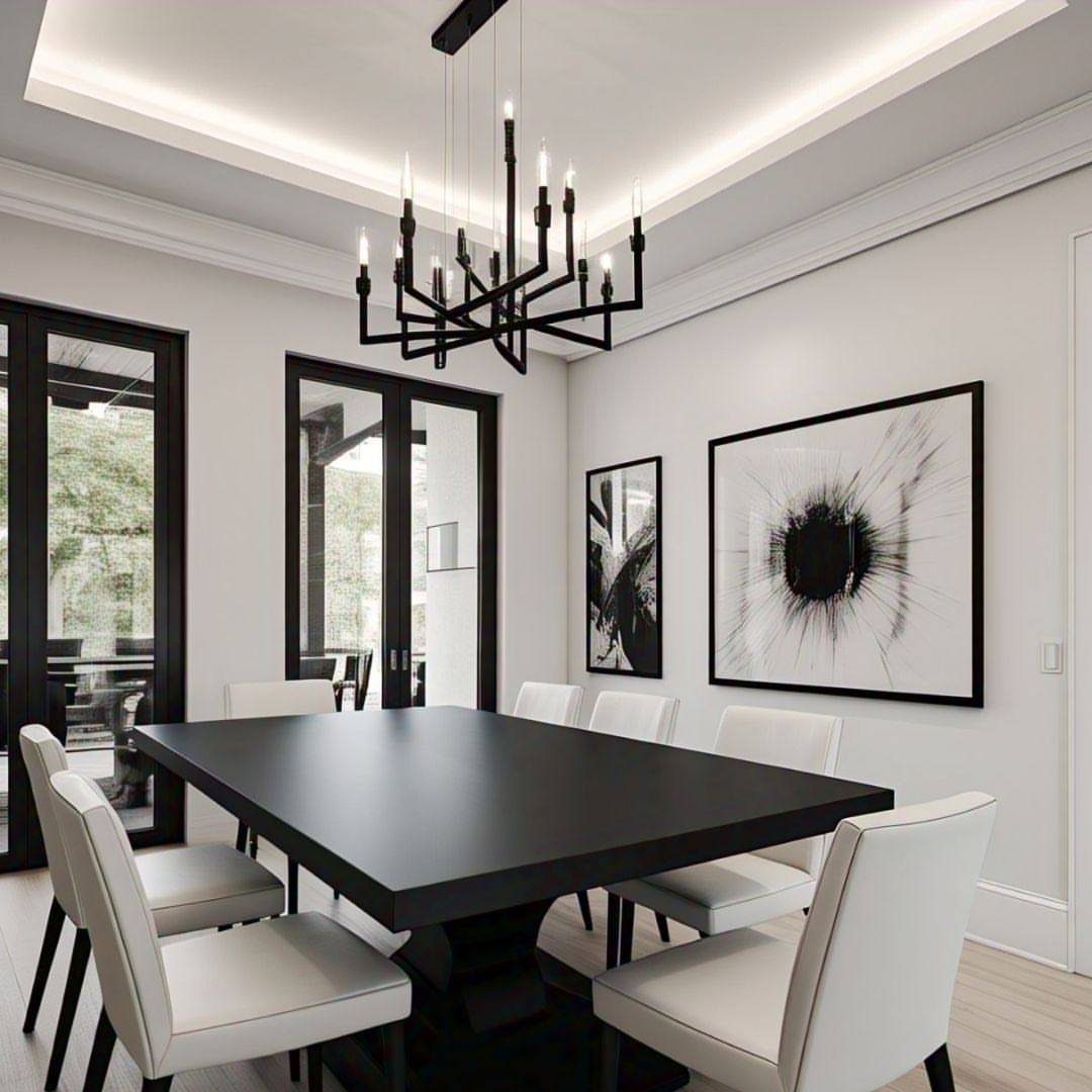 Black dining table and white chairs in a monochrome room with abstract art.