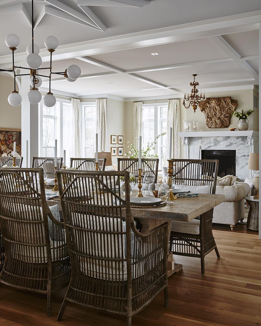 Rustic reclaimed wood dining table with woven wicker chairs in a bright room