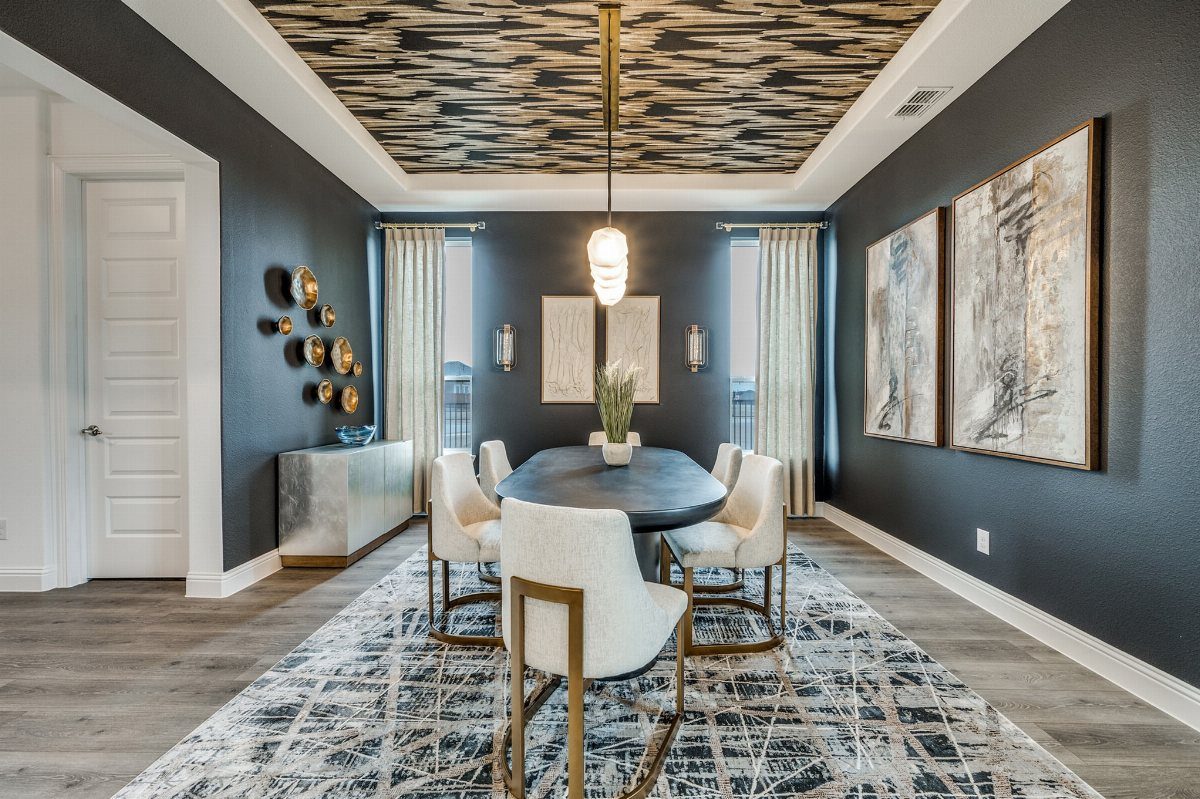 Dining room with a recessed tray ceiling featuring gold and black textured patterns.