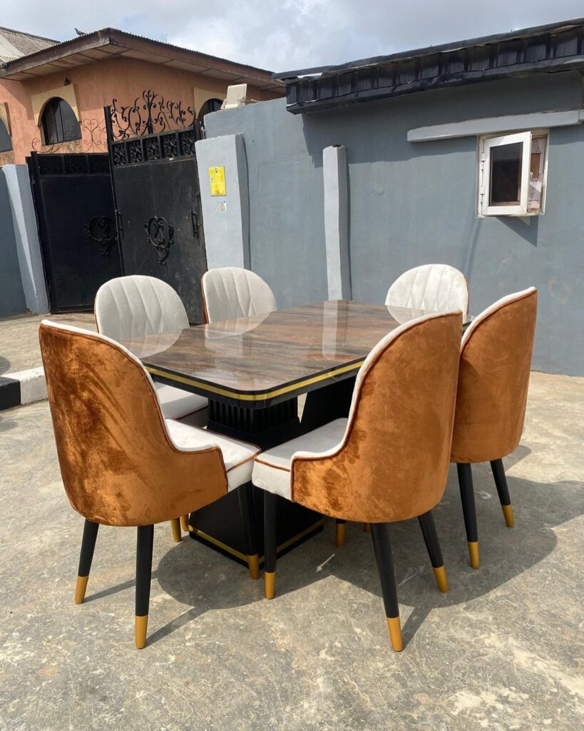 Marble dining table with mixed tan and white upholstered chairs outdoors