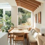 Light wood dining table with matching chairs and a cushioned wooden banquette seat.
